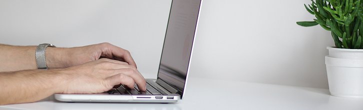 Hände die auf einem Laptop tippen
