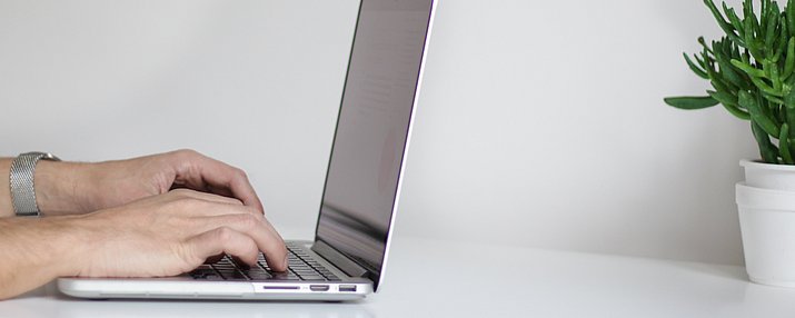 Hände die auf einem Laptop tippen